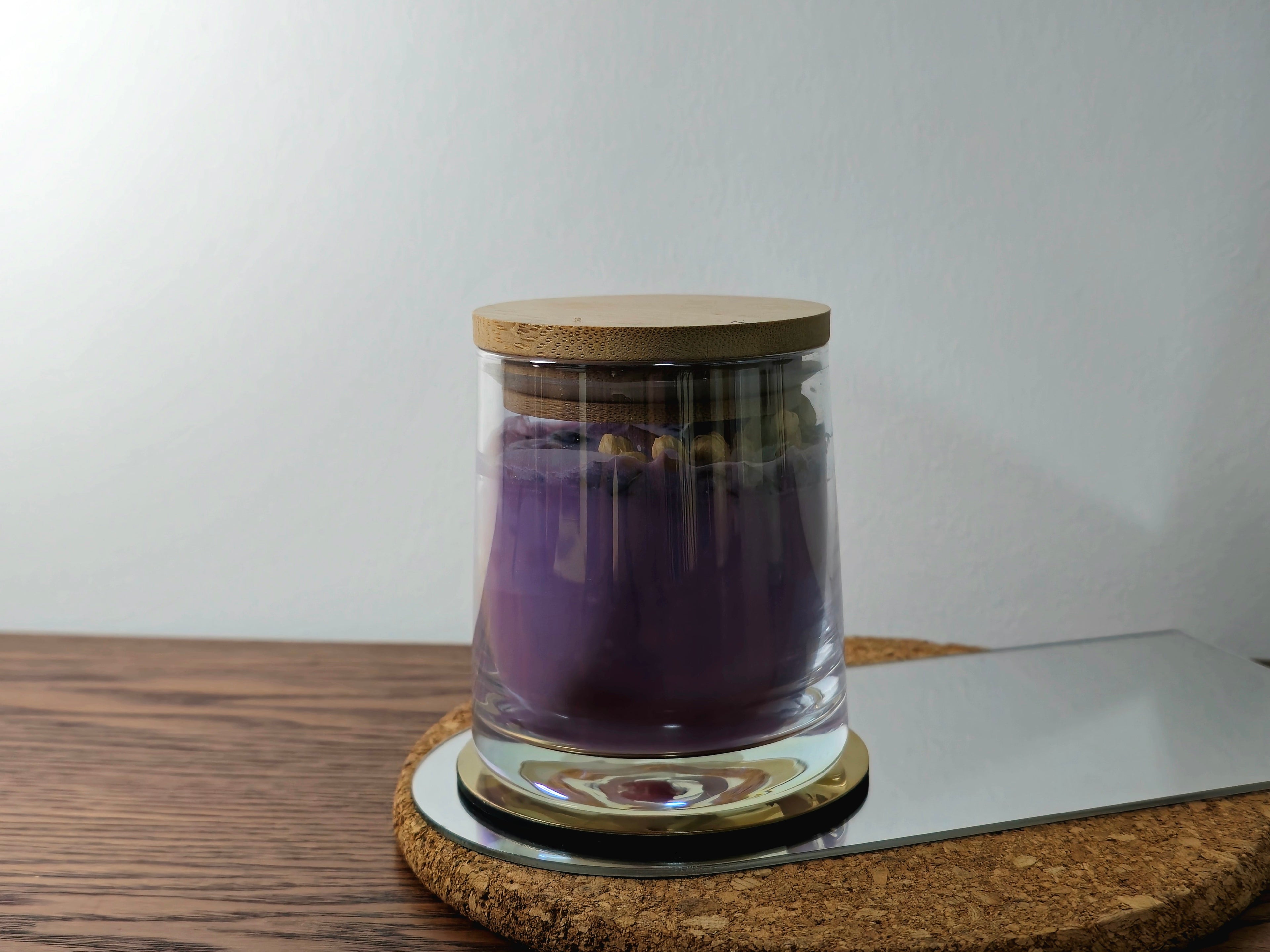 Candle Glass jar with cork lid on a wooden coaster with a white background